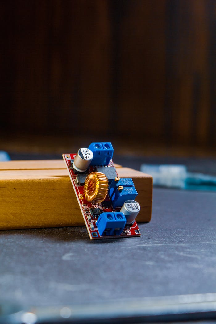 Detailed shot of a circuit board with components on a wooden surface, perfect for technology themes.