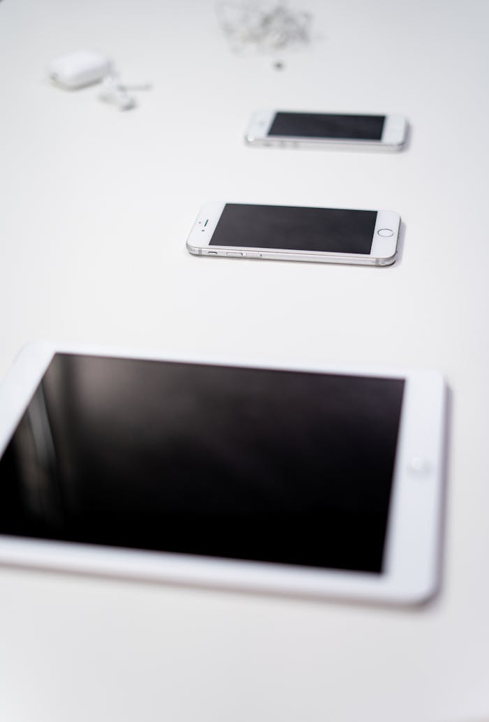 Collection of Apple gadgets including smartphones and tablets on a white background.